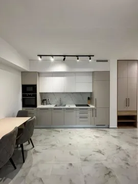Modern kitchen with built-in appliances and a dining table. - image 6