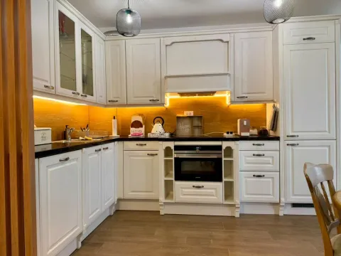 Modern white kitchen with built-in appliances and LED lighting. - image 15