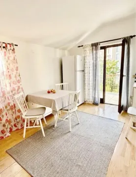 Smaller kitchen with a dining table and balcony access. - image 4