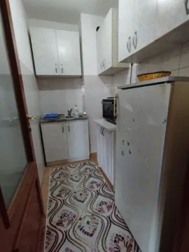 A small and functional kitchen with white cabinets and a refrigerator. - image 3