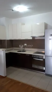Kitchen equipped with white upper and dark lower cabinets and built-in appliances. - image 10