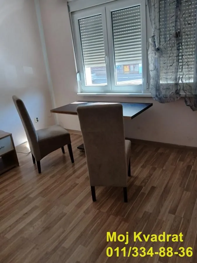 Dining table with two chairs by the window.