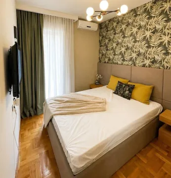 Furnished bedroom with a double bed, wallpaper, and parquet flooring. - image 8