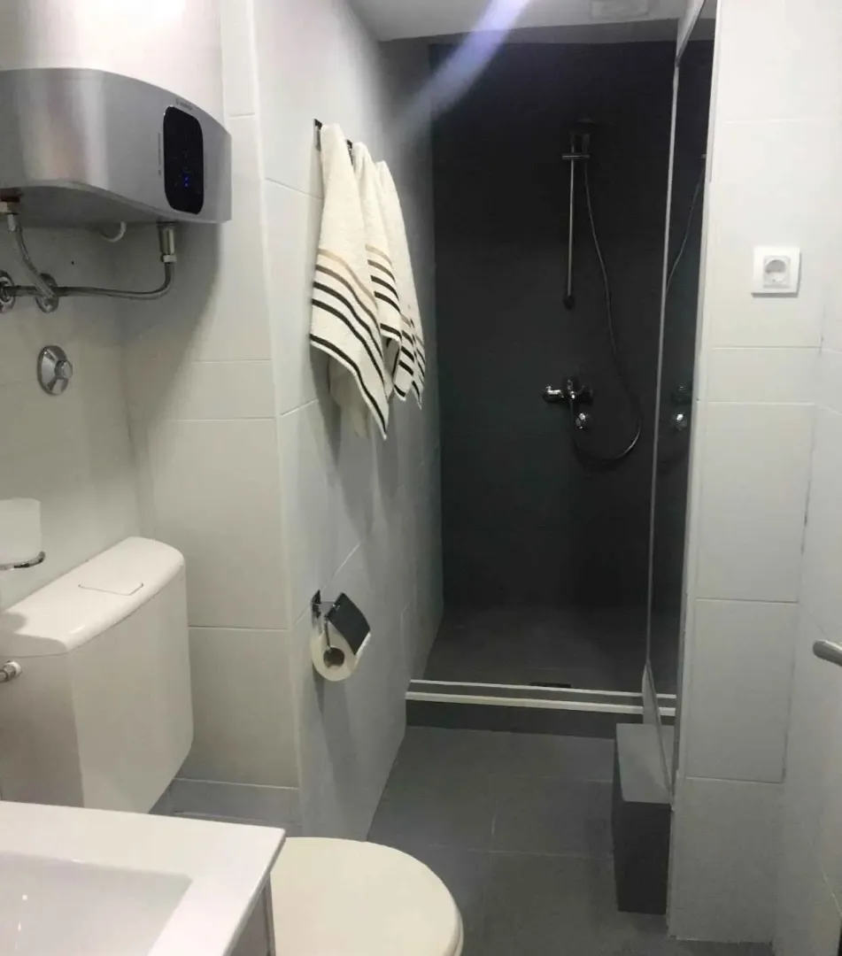 Moderno kupatilo sa tuš kabinom i bojlerom.