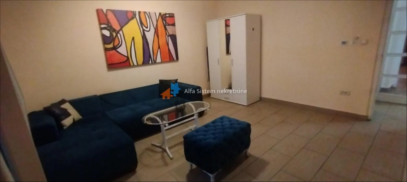 Living room with a blue sofa, coffee table, and painting on the wall.