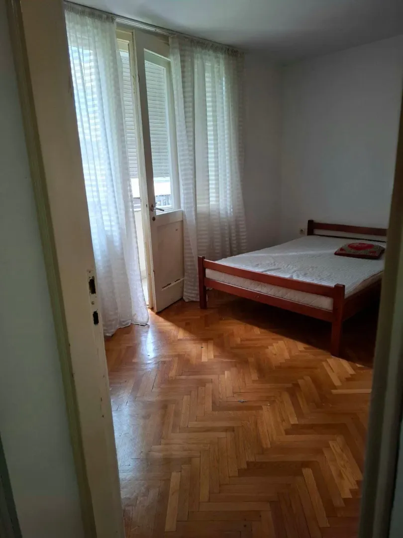 Bedroom with a wooden bed and access to the terrace.