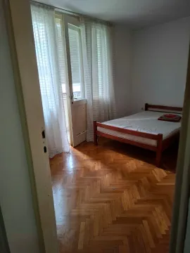 Bedroom with a wooden bed and access to the terrace. - image 4