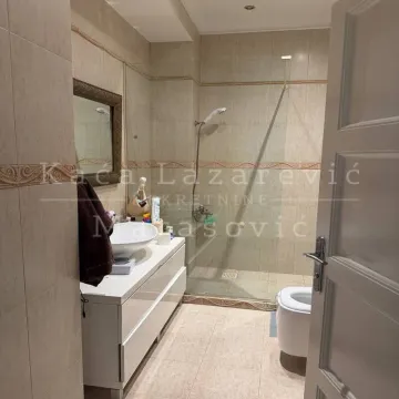 Kupatilo sa tuš kabinom, umivaonikom i WC šoljom obloženo keramičkim pločicama. - image 2