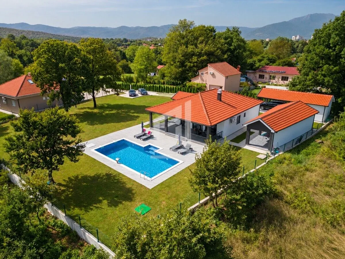 Aerial view of the property with a house, swimming pool, and landscaped yard.