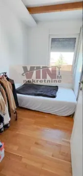 Manja spavaća soba sa krevetom i drvenim podom. - image 7