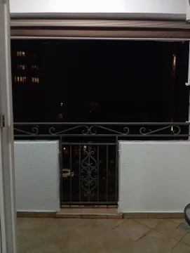 Natkriveni balkon sa metalnom ogradom i pogledom noću. - image 7