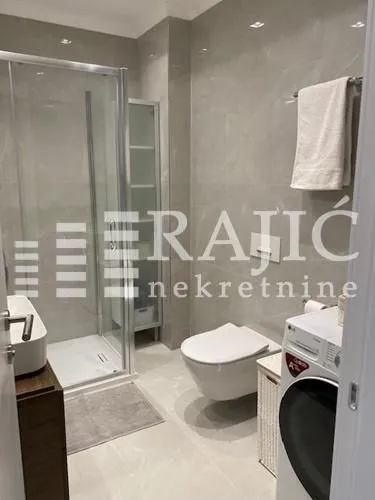 Modernly equipped bathroom with a shower cabin, sink, and sanitary facilities.