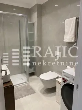 Modernly equipped bathroom with a shower cabin, sink, and sanitary facilities. - image 3