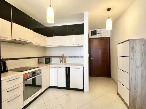 Kitchen equipped with white and black cabinets and built-in appliances. - image 2