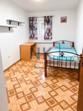Small bedroom with a bed, desk, and a window. - image 11