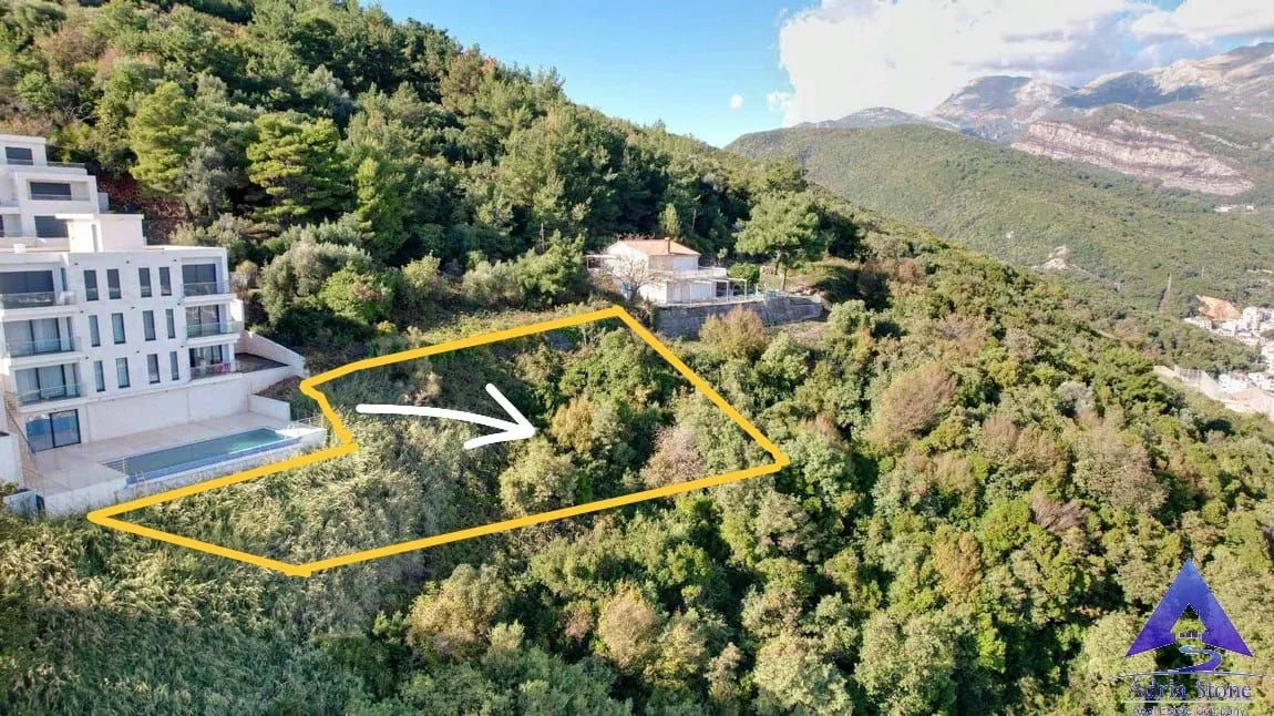 Pogled iz vazduha na građevinsku parcelu sa ucrtanim granicama i okolnim zelenilom.