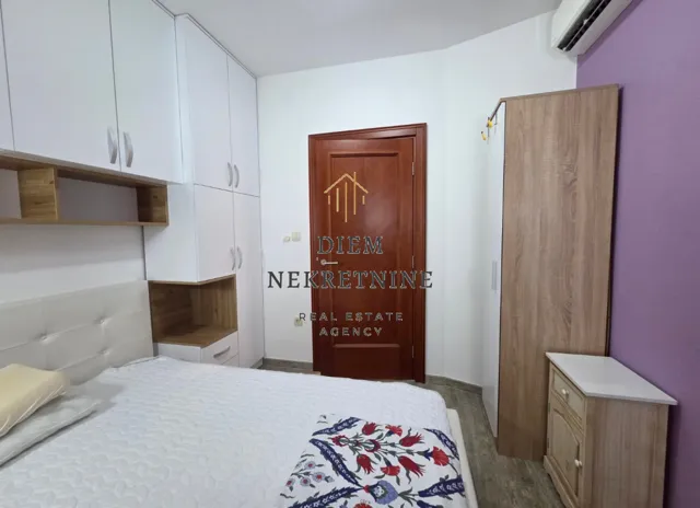 Furnished bedroom with white wardrobes and a double bed.