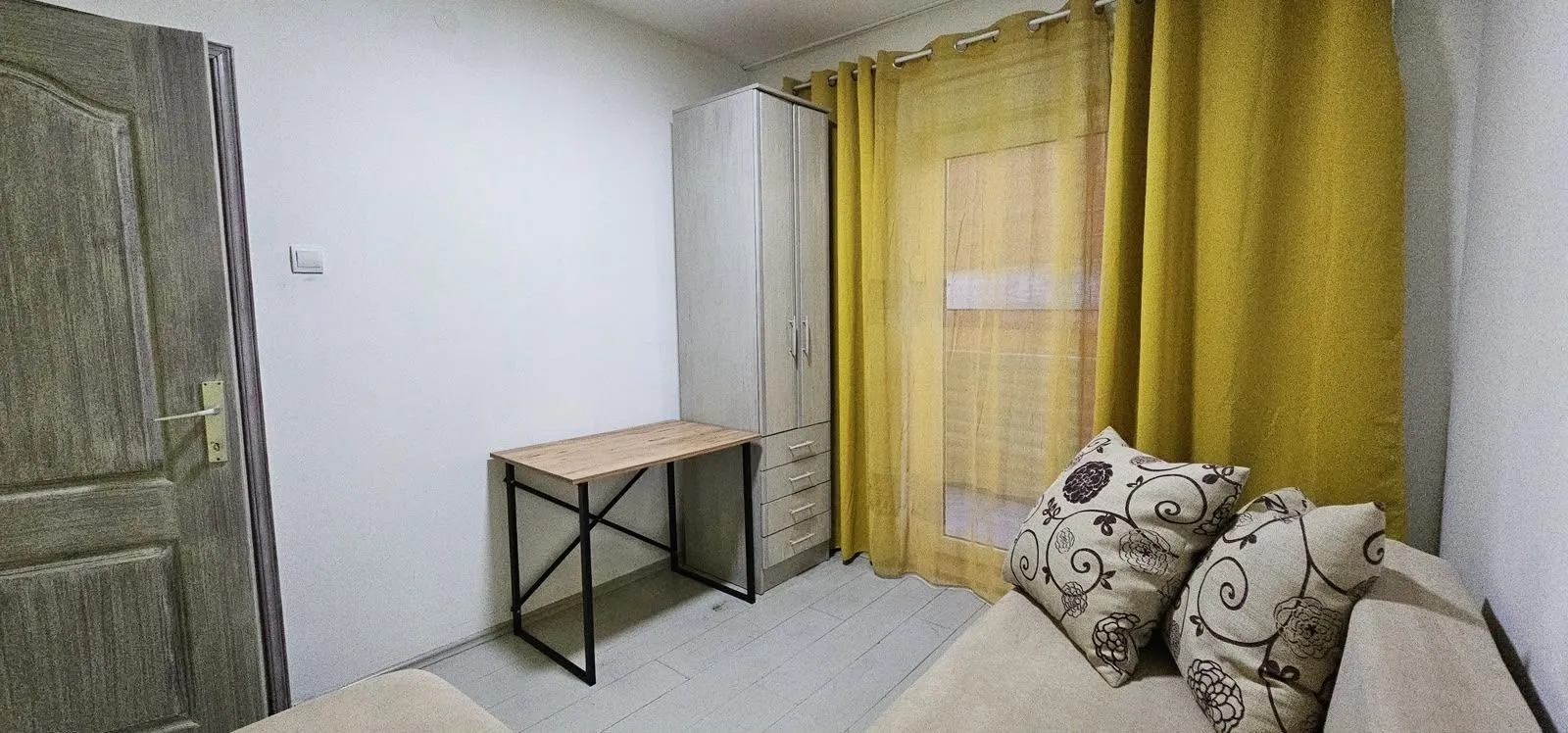 Small room with a bed, desk, and wardrobe.