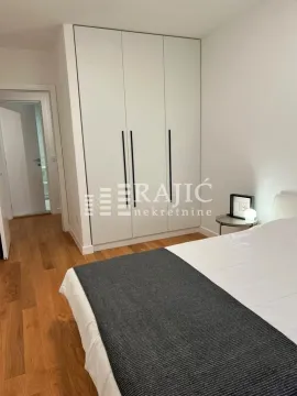 Bedroom with a large built-in wardrobe and a bed. - image 6