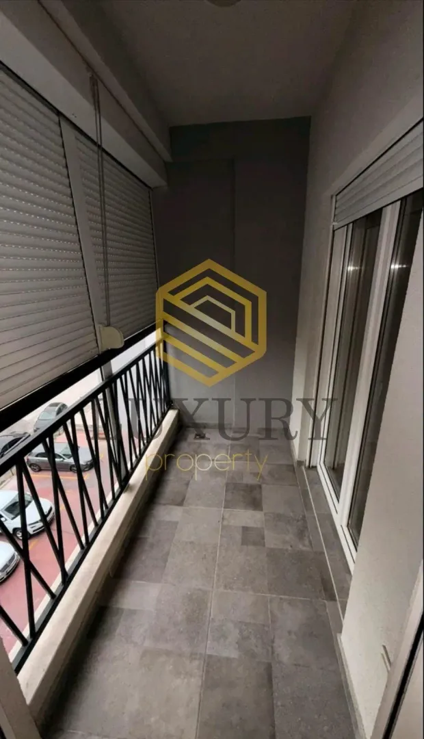 Smaller enclosed balcony with tiled floor and metal railing.