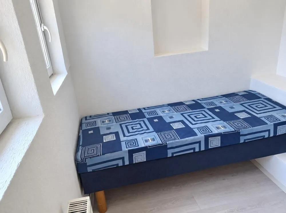 Smaller bedroom with a bed and a window.