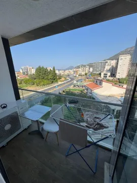 Namješten balkon sa stolom, stolicama, sušilicom za veš i pogledom na grad. - image 8