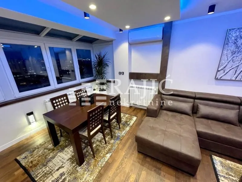 Living room with dining area and modern lighting.