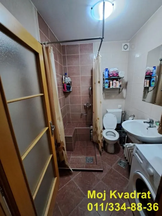 Kupatilo sa tuš kabinom, umivaonikom, WC šoljom i veš mašinom.