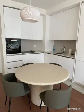 Moderna bela kuhinja sa trpezarijskim stolom i stolicama. - image 7