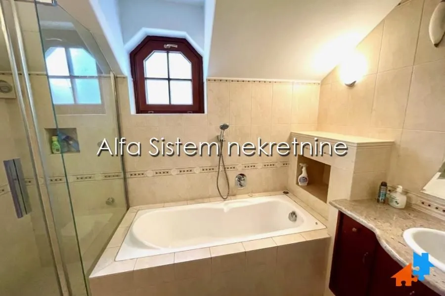 Bathroom with a bathtub, shower cabin, and washbasin.