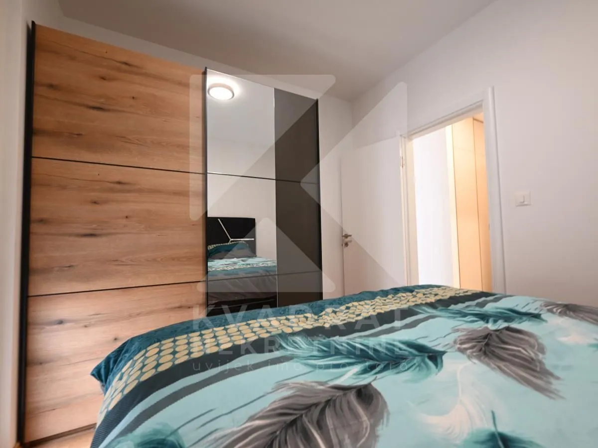 Bedroom with a large mirrored wardrobe and a double bed.