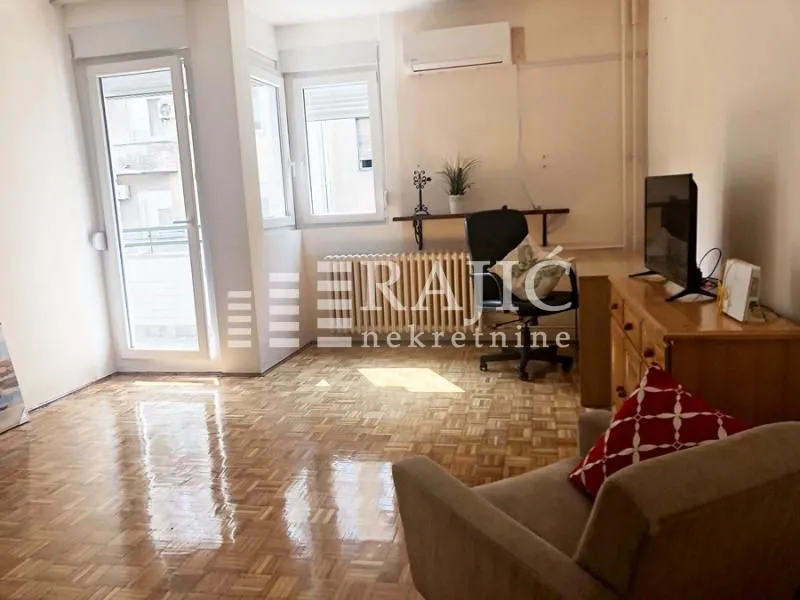Living room with parquet flooring, furniture, and access to the terrace.