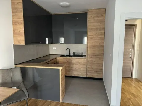 Modern kitchen featuring a combination of wooden and dark grey cabinets. - image 3
