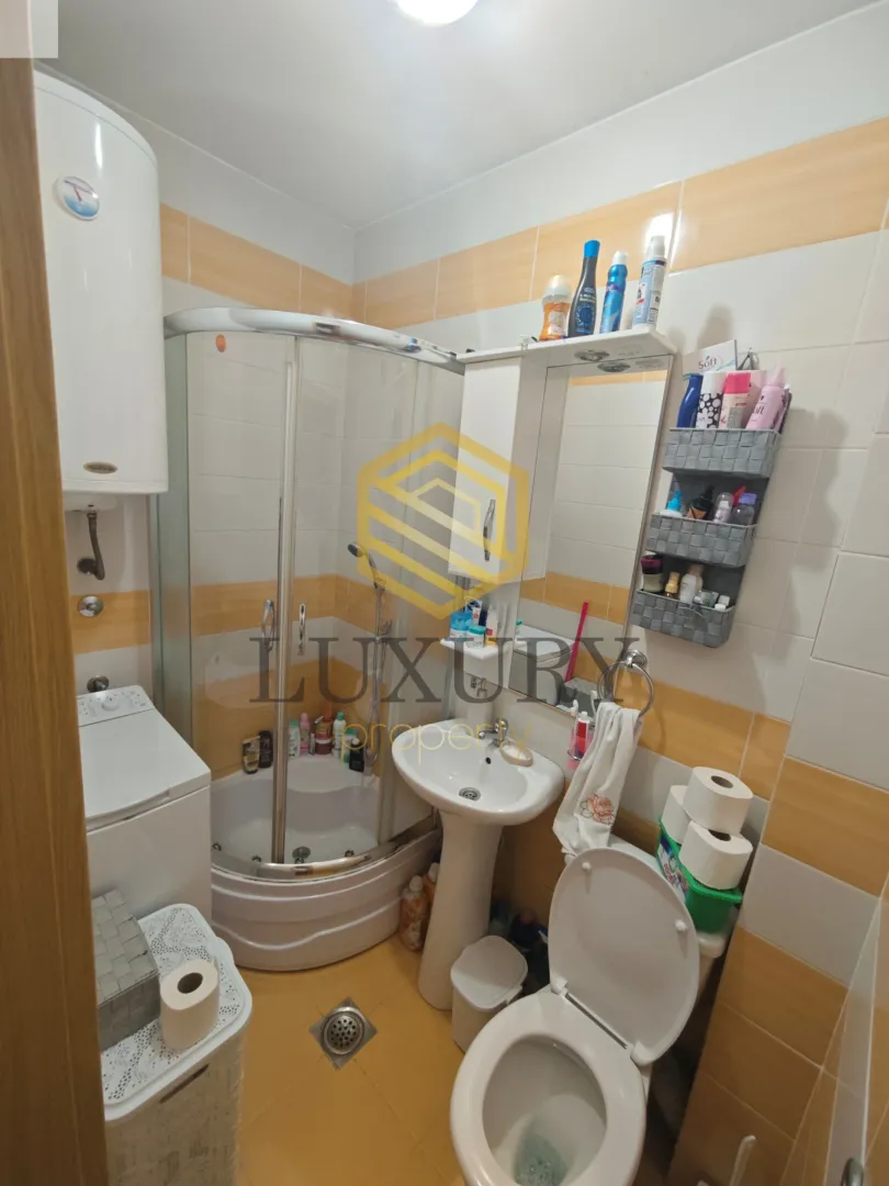 Manje kupatilo sa tuš kabinom, umivaonikom i WC šoljom.