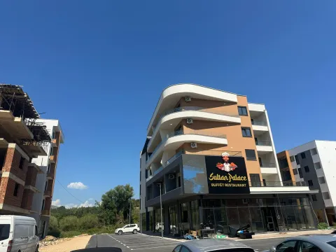 Exterior of a modern multi-family building with commercial space on the ground floor and parking. - image 9