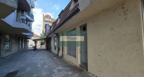 View of the building exterior with a paved courtyard and commercial space. - image 3