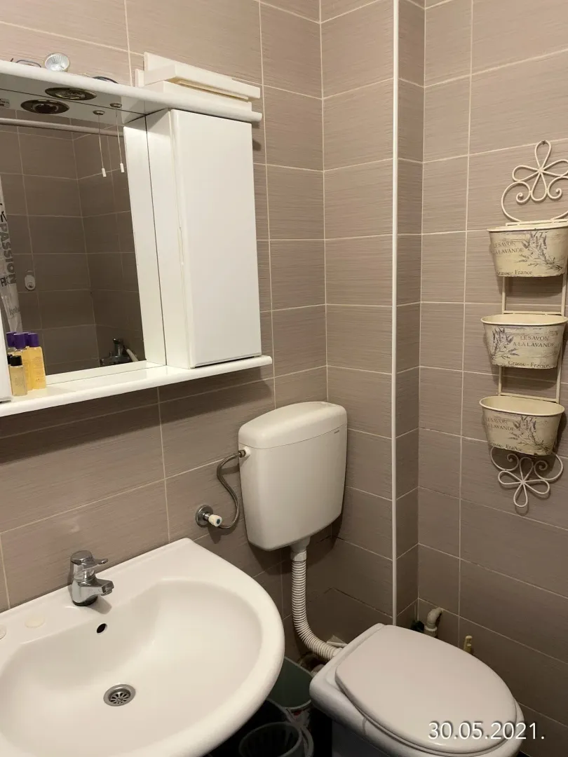 Small bathroom with a sink, toilet, and mirrored cabinet.