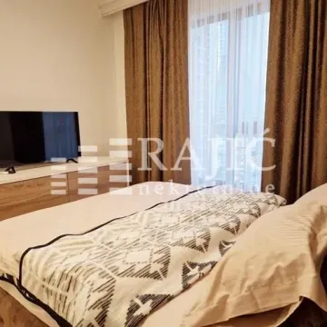 Furnished bedroom with a double bed, television, and a window with curtains. - image 7