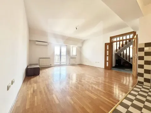 Spacious empty living room with wooden flooring and a staircase in the background. - image 2