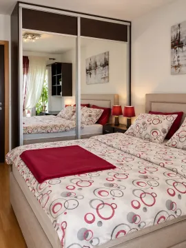 Furnished bedroom with a large double bed and a fitted wardrobe with mirror doors. - image 4