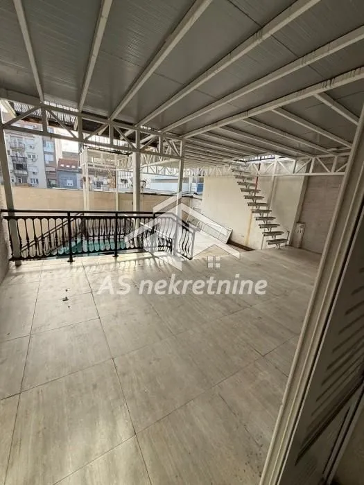 Large covered terrace with a metal structure and stairs.