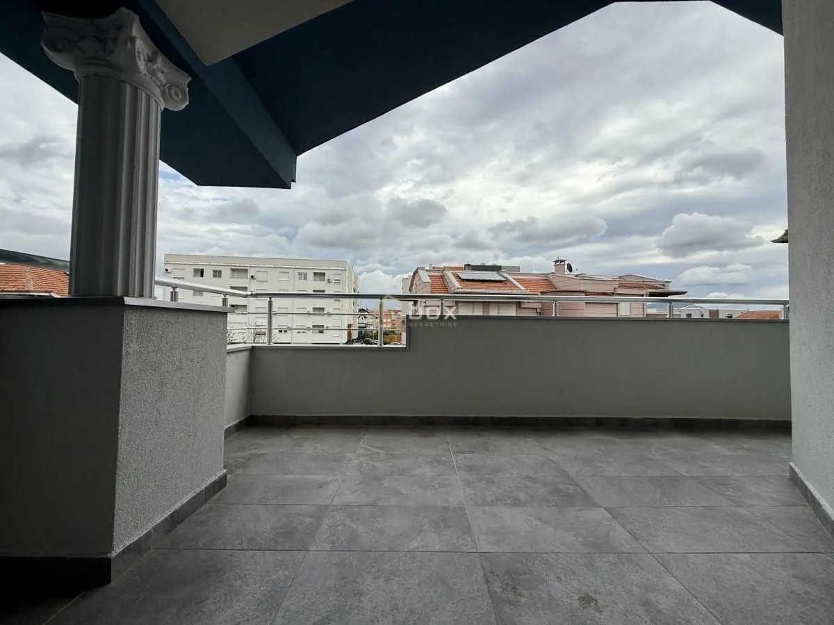 Spacious covered terrace with a view of the neighborhood and surrounding buildings.