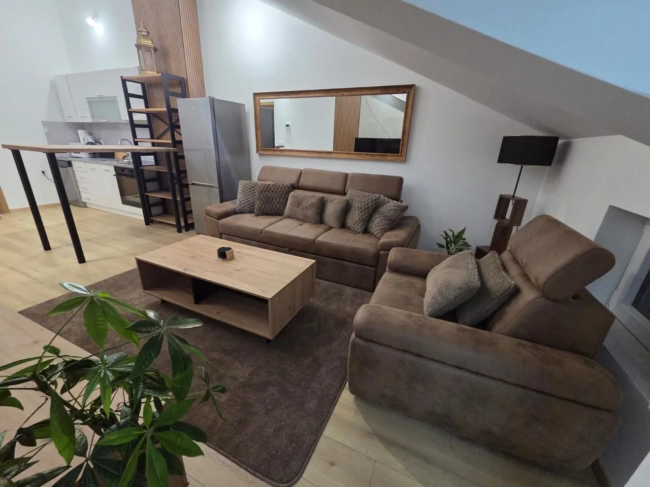 Living room with a sofa, coffee table and a view of the kitchen.