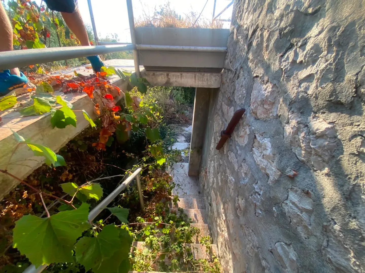 Spoljni dio nekretnine sa kamenim zidom i stepeništem.