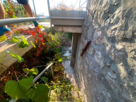 Spoljni dio nekretnine sa kamenim zidom i stepeništem. - image 5
