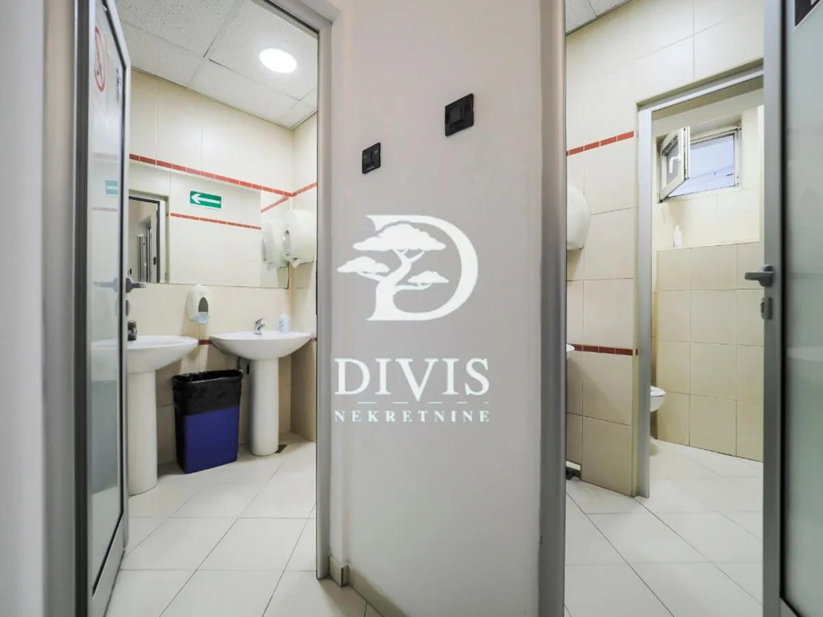 View of a tiled bathroom with sinks and toilets.