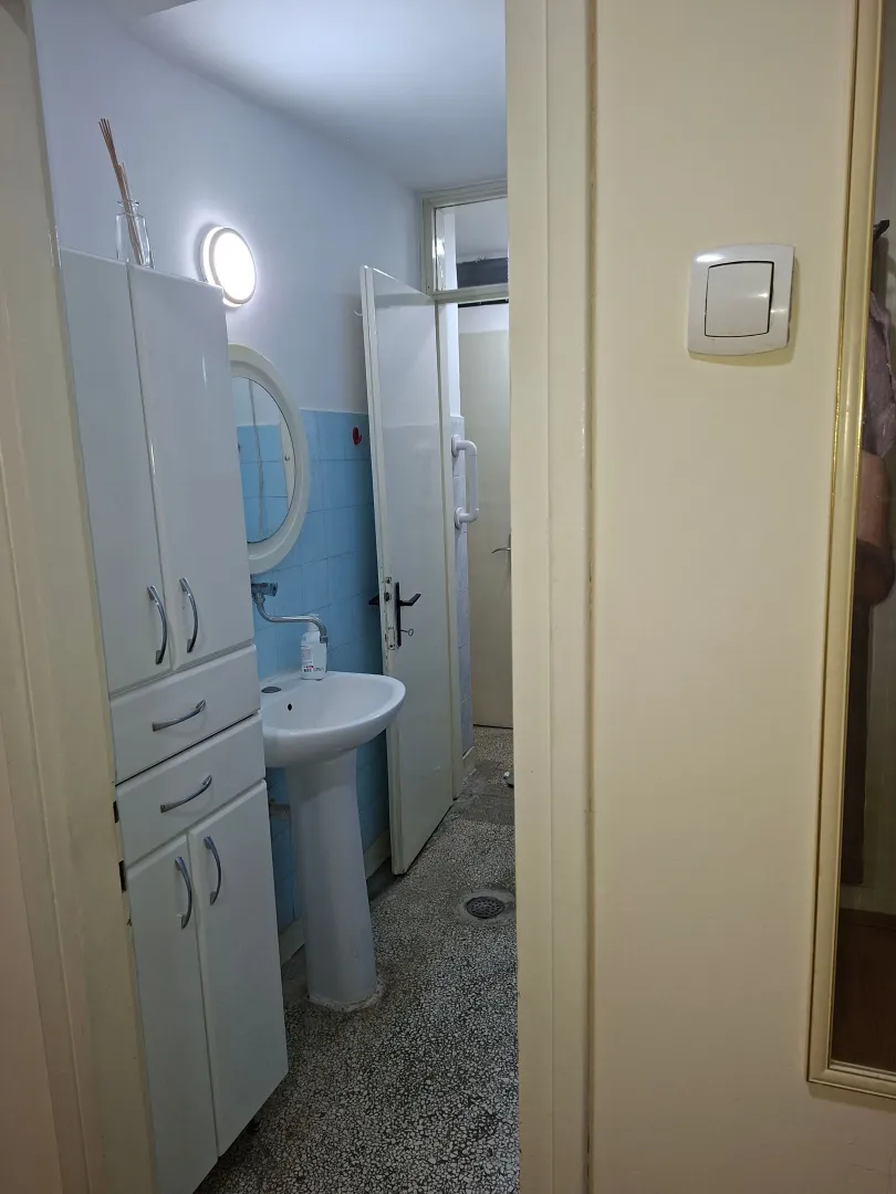View of the bathroom with a washbasin and a white cabinet.