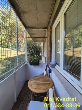 Manji zatvoreni balkon sa drvenim stolom i stolicama. - image 15