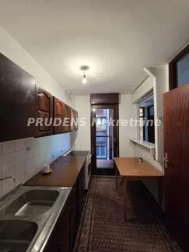 Starija kuhinja sa drvenim elementima i trpezarijskim stolom. - image 7