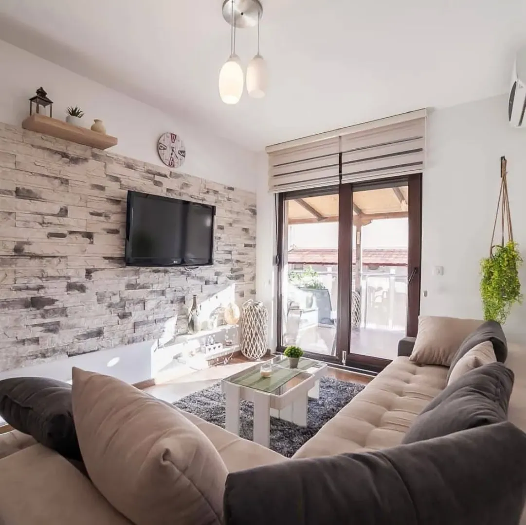 Living room with sofa, TV and access to the terrace.